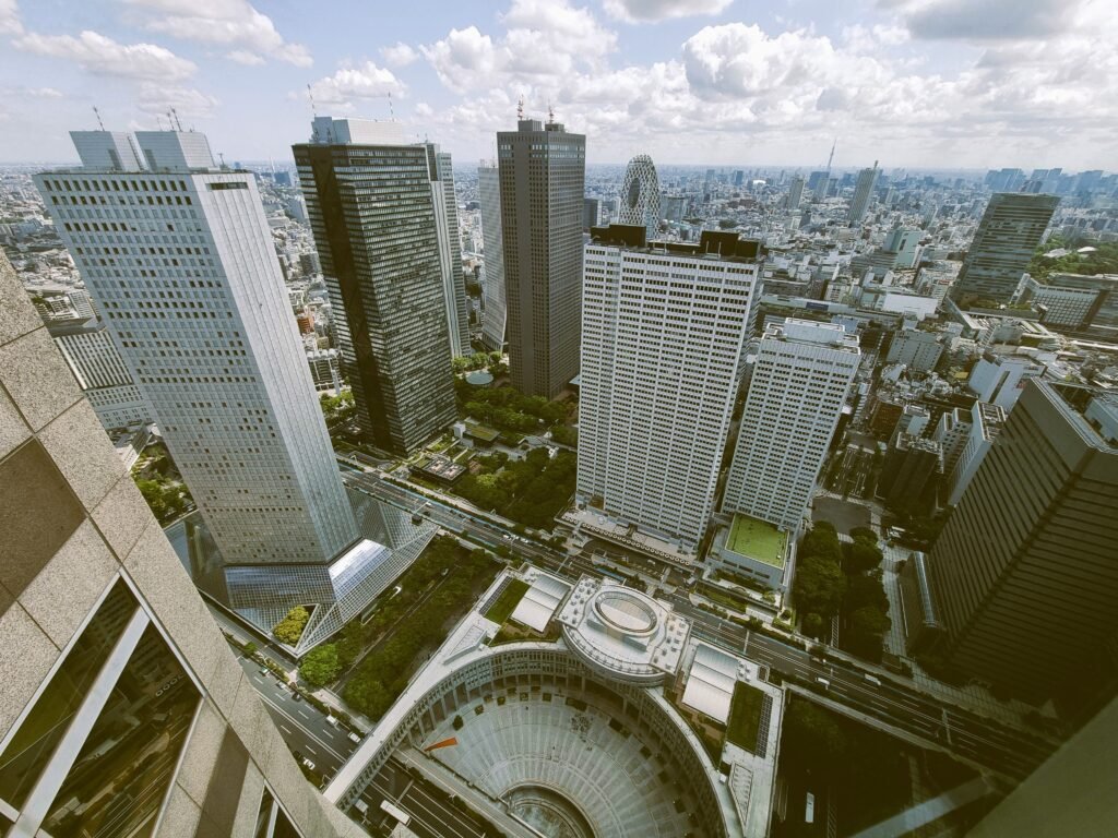 Persona llenando formularios de solicitud bancaria en una sucursal moderna de Tokio con una laptop.