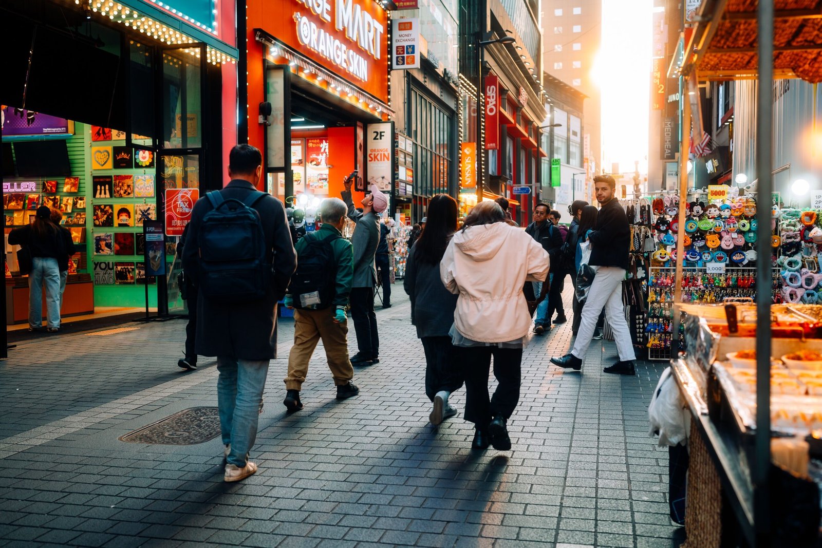 Persona caminando por una calle de una ciudad surcoreana con mochila y mapa
